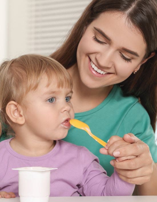 Woman with child eating yogurt
