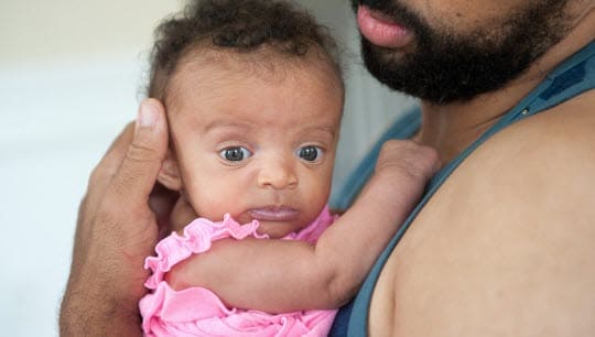 A man holding a tiny baby