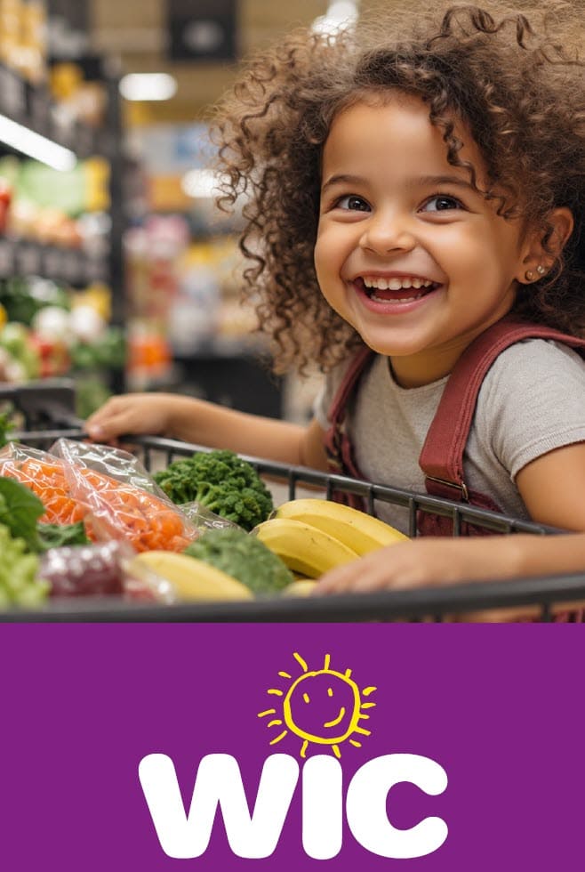 A young child sits in a grocery cart filled with fresh produce, including bananas, broccoli, and packaged vegetables, inside a grocery store. A purple banner with the word “WIC” and a simple yellow smiling sun appears at the bottom of the image.