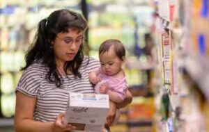 woman and baby looking at box of cereal